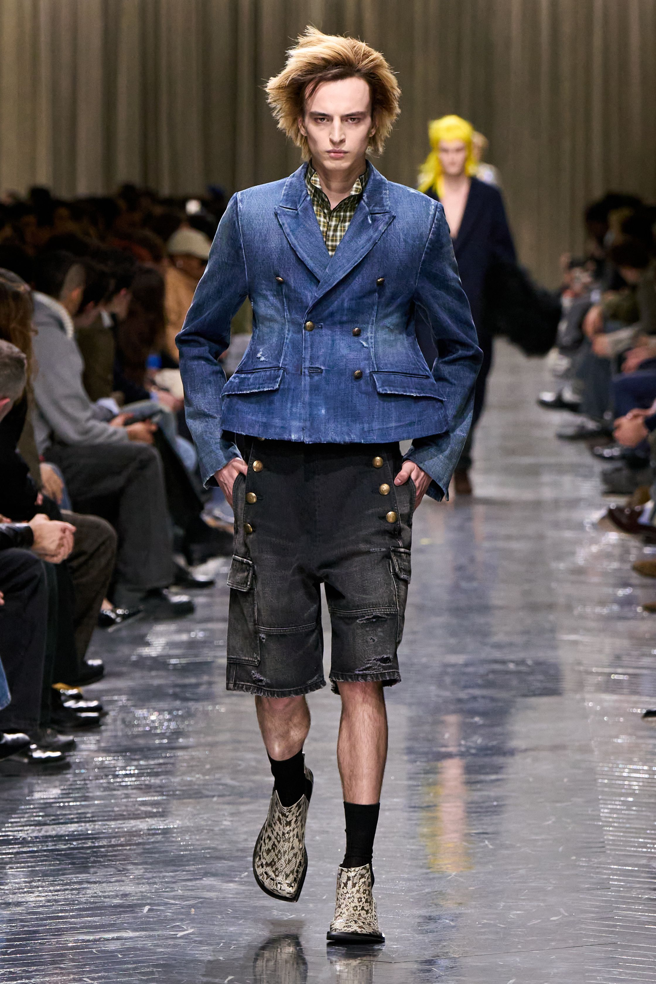 本季 Dior Men 2026 秋冬在克制与叛逆之间建立起新的男性气质坐标。轮廓上，柔软针织、披风式外套与军装结构形成张力对照，模糊正装与休闲、性别与功能的边界；材质层面，羊毛、皮革、毛绒与轻量技术面料并置，强化“触感叙事”。色彩从学院派的灰蓝、橄榄绿过渡至点状印花与手工肌理，传递一种被精心编排的随性。整体呈现出一种“新贵游牧者”形象：既有高级定制的工艺根基，又拥抱当代青年对自由、混搭与身份流动性的渴望-顽石频道趋势研究